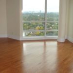 Custom hardwood flooring by Meistercraft adds warmth and natural beauty to this urban highrise apartment with a view of surrounding buildings and parkland