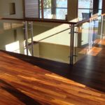 Rich and lustrous custom hardwood floor by Meistercraft Wood Flooring complements this glass and wood partition