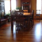 Rich, dark solid hardwood flooring by Meistercraft Wood Flooring is the anchor in this elegant dining area