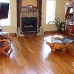 Rich, toffee-coloured solid hardwood flooring by Meistercraft Wood Flooring adds elegance to this livingroom