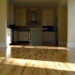 The beauty of solid maple brightens this kitchen; custom flooring by Meistercraft Wood Flooring