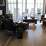 Livingroom overlooking porch and lake; custom hardwood flooring by Meistercraft Wood Flooring
