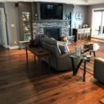 Lustrous solid hardwood flooring complements the stone fireplace and hearth in this elegant livingroom; custom wood flooring by Meistercraft