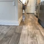 Gray hardwood complements off-white island in this modern open concept kitchen; custom hardwood floor by Meistercraft Wood Flooring