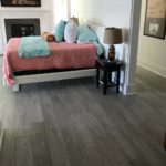 Gray hardwood flooring complements the white decor in this modern bedroom; custom hardwood floor by Meistercraft Wood Flooring