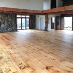 Solid hardwood flooring complements the stone walls in this massive great room; hardwood flooring by Meistercraft Wood Flooring
