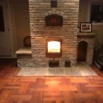 Intricate hardwood flooring pattern complements a massive and beautiful stone hearth and oven; custom flooring by Meistercraft Wood Flooring